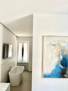 a bathroom with a bath tub and a painting on the wall at TRASTEVERE URBAN SUITE in Rome