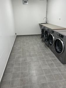 uma lavandaria com 2 máquinas de lavar roupa num piso de azulejo em Fjällglim36 em Sälen