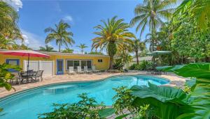 une piscine en face d'une maison avec des palmiers dans l'établissement Crescent Cottage - 1034, à Siesta Key