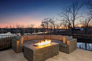 eine Couch auf einer Terrasse mit einer Feuerstelle in der Unterkunft Lakefront Home Insane Views - Pool Spa Gameroom in Kingsland