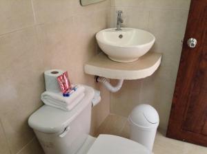 Un baño blanco con lavabo e inodoro. en Posada Malix Pek, en Tulum 35 fotos más