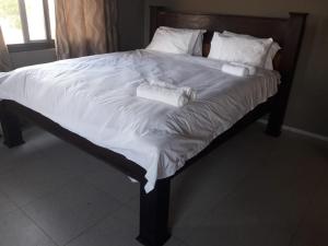 a large bed with white sheets and pillows on it at BLUE HEAVEN in Vilanculos