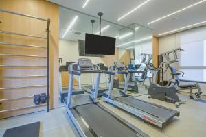 a gym with several tread machines and a flat screen tv at Roomo Vila Mariana Vergueiro Residencial in Sao Paulo