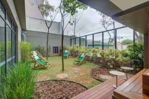 a patio with two lawn chairs and a tree at Roomo Vila Mariana Vergueiro Residencial in Sao Paulo