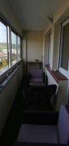 um quarto com uma varanda com cadeiras e janelas em Chambre privé avec loggia chez l'habitant em Champigneulles