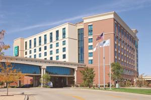 un edificio con una bandera americana delante de él en Embassy Suites East Peoria Hotel and Riverfront Conference Center, en Peoria