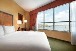a hotel room with a large bed and a large window at Embassy Suites East Peoria Hotel and Riverfront Conference Center in Peoria