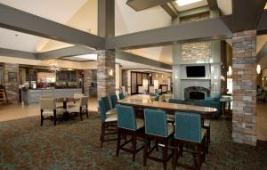 a lobby with a table and chairs and a fireplace at Homewood Suites by Hilton Alexandria in Alexandria