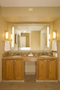 baño con 2 lavabos y espejo grande en Homewood Suites by Hilton Alexandria, en Alexandria