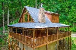 a cabin in the woods with a metal roof at Papa's Bear Nest in Sevierville