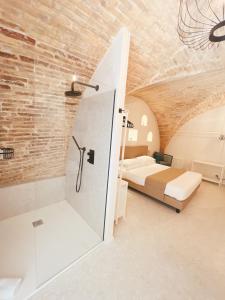 a bedroom with a bed and a glass shower at Il Timbro - Dimore Diffuse in Vasto