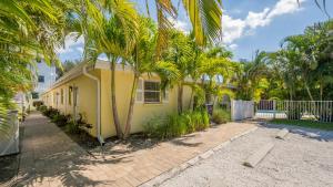 ein gelbes Haus mit Palmen davor in der Unterkunft Casita Sun Star - 1135 in Siesta Key