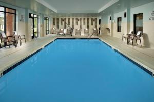 una gran piscina con sillas y mesas en Hampton Inn & Suites Baltimore North/Timonium, MD, en Timonium