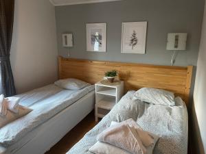 a bedroom with two beds and a night stand at Tärnaby Rooms & Apartments in Tärnaby