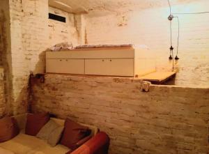 a room with a brick wall with a couch in it at Hip center basement studio in Vienna