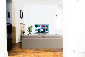 a living room with a couch and a tv at Daze Private 1BR Near to City Centre in Liverpool