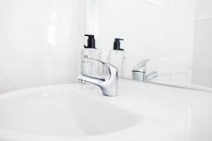 a bathroom sink with a faucet and a mirror at Daze Private 1BR Near to City Centre in Liverpool