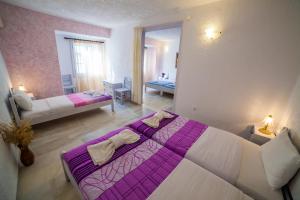 a bedroom with a purple and white bed in a room at St.George Valsamitis in Katapola