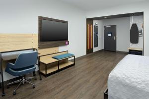 ein Hotelzimmer mit einem Bett, einem Schreibtisch und einem TV in der Unterkunft Tru By Hilton Denver Airport Tower Road in Denver