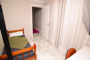 Habitación pequeña con 1 cama y 1 dormitorio pequeño. en ASP hospedaria, en Paranaguá