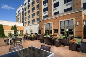 a patio with tables and chairs in front of a building at DoubleTree by Hilton Dulles Airport-Sterling in Sterling
