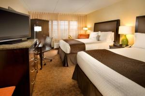 a hotel room with two beds and a flat screen tv at DoubleTree by Hilton Dulles Airport-Sterling in Sterling