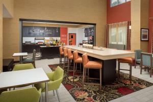 a restaurant with a bar and chairs and a kitchen at Hampton Inn & Suites Lakeland-South Polk Parkway in Lakeland