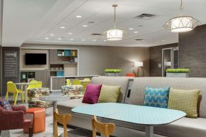 a lobby with a couch and tables and chairs at Home2 Suites By Hilton Clermont in Clermont