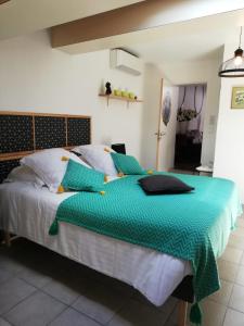 a bed with a green comforter in a bedroom at atmosphere in Poilhès