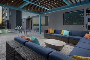 a living room with blue couches and a pool at Tru By Hilton Lubbock Southwest in Lubbock