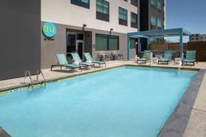 a large swimming pool with chairs and a building at Tru By Hilton Lubbock Southwest in Lubbock