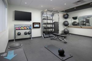 Tru By Hilton Lubbock Southwest في لوبوك: صالة ألعاب رياضية مع غرفة وزن مع مقعد وأوزان