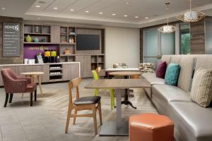 a living room with a couch and a table and chairs at Home2 Suites By Hilton Miami Doral West Airport, Fl in Miami