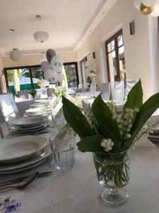 stół jadalny z talerzami i kwiatami w wazie w obiekcie Grot w mieście Mrzeżyno