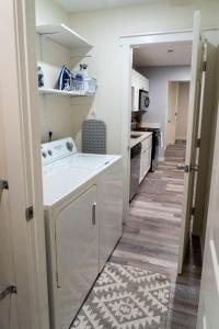 a kitchen with a washer and dryer in it at Madrona's Cottage- Fully fenced and pet friendly in Charleston