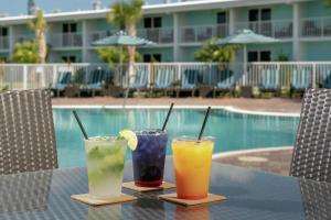 three cocktails sitting on a table next to a pool at Hampton Inn Marathon - Florida Keys in Marathon