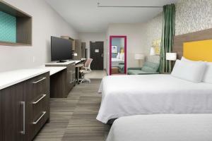 Home2 Suites By Hilton Phoenix Airport South في فينكس: غرفة فندقية بسريرين ومكتب