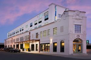 a white building with cars parked in front of it at Tru By Hilton San Antonio Downtown Riverwalk in San Antonio