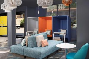 ein blaues Sofa in einem Zimmer mit Tischen und Stühlen in der Unterkunft Tru By Hilton San Antonio Downtown Riverwalk in San Antonio