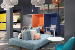 a blue couch in a room with tables and chairs at Tru By Hilton San Antonio Downtown Riverwalk in San Antonio