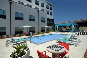 a pool with chairs and a table and a building at Tru By Hilton San Antonio Downtown Riverwalk in San Antonio