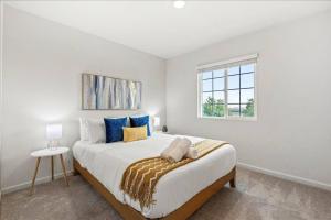 a white bedroom with a large bed and a window at Only available on other site in Sacramento