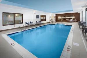 duży basen z niebieską wodą w budynku w obiekcie Hampton Inn & Suites Falls Church w mieście Falls Church