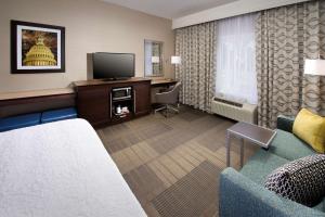 Pokój hotelowy z kanapą i telewizorem w obiekcie Hampton Inn & Suites Falls Church w mieście Falls Church