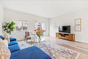 a living room with a blue couch and a tv at Only available on other site in Sacramento