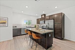 a kitchen with a island with chairs and a refrigerator at Only available on other site in Sacramento