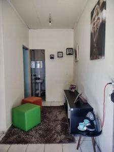 uma sala de estar com uma cadeira verde e uma secretária em Studio 2 próximo ao Centro em Palmas