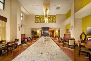 un gran vestíbulo con una mesa larga y sillas en Hampton Inn and Suites San Antonio Airport en San Antonio