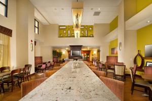 a large lobby with a long table and chairs at Hampton Inn and Suites San Antonio Airport in San Antonio
