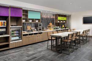 a restaurant with a counter with bar stools at Home2 Suites By Hilton Asheville Biltmore Village in Asheville